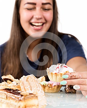 Young woman eating cupcakes with pleasure after a diet