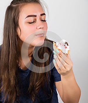 Young woman eating cupcakes with pleasure after a diet