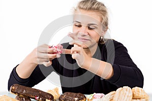 Young woman eating cupcakes with pleasure after a diet