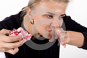 Young woman eating cupcakes with pleasure after a diet