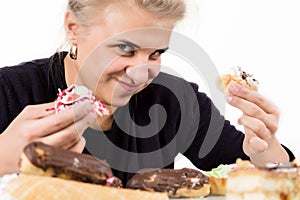 Young woman eating cupcakes with pleasure after a diet