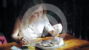 Young woman eating fast food, black hamburger