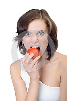 Young woman eating a fresh tomato.