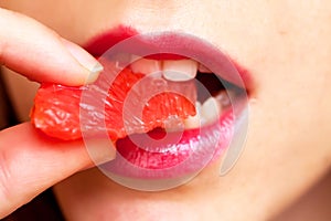 Young woman eating grapefruit