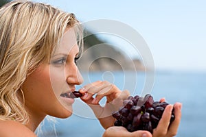 Young woman eating grapes