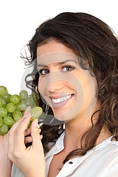 Young woman eating grapes