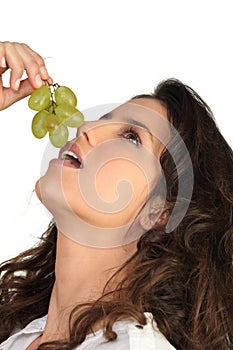 Young woman eating grapes