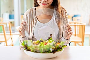 Young woman eating a healthy salad mixes with vegetable and fruit at the restaurant, Healthy lifestyle and diet concept