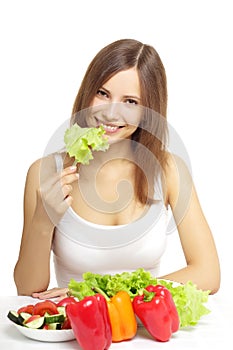 Young woman eating healthy salad on white