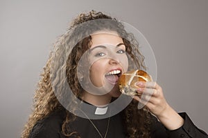Young woman eating a Hot Cross bun