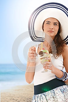 Mladá žena jesť zmrzlina na leto pláž 