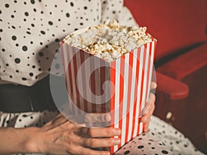 Young woman eating popcorn in movie theater