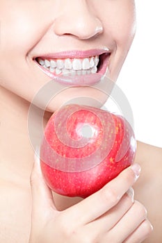 Young woman eating red apple with health teeth