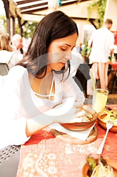 Young woman is eating in restaurant.