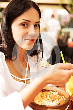 Young woman is eating in restaurant.