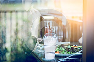 Young woman eating salad and beverage in cafe. Focus woman