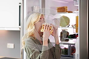 Young Woman Eating Sandwich In Front