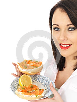 Young Woman Eating Smoked Salmon and Cream Cheese Bagel