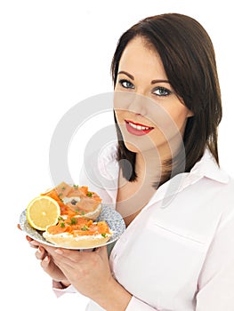Young Woman Eating Smoked Salmon and Cream Cheese Bagel