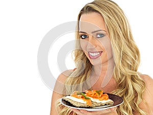 Young Woman Eating Smoked Salmon and Cream Cheese on a Cracker