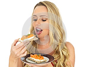 Young Woman Eating Smoked Salmon and Cream Cheese on a Cracker