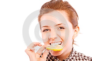 Young woman eating sour lemon, making grimace