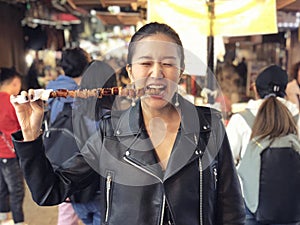 Young woman eating Steamed Octopus Legs at  at Myeong-dong street food, Seoul, South Korea photo