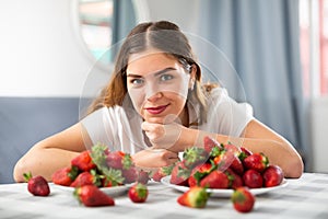 Young woman eating strawberry at home