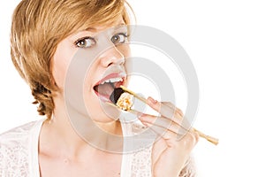 Young woman eating sushi in an Asian restaurant