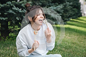 A young woman eating sushi in the park, picnic in nature.