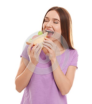 Young woman eating tasty sandwich on white