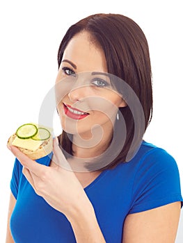 Young Woman Eating Toasted Crumpet with Cheese and Cucumber