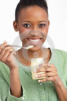 Young Woman Eating Yoghurt In Studio