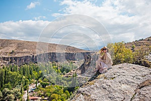 Young woman on the edge of canyon in Cappodocia