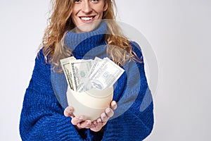 Young woman with an egg and money in hand