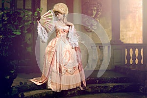 Young woman in eighteenth century image posing in vintage exterior