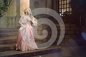 Young woman in eighteenth century image posing in vintage exterior