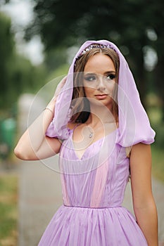 Young woman in elegant evening dress with hood, outdoors