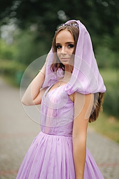 Young woman in elegant evening dress with hood, outdoors