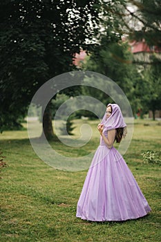 Young woman in elegant evening dress with hood, outdoors