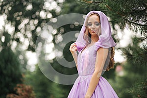 Young woman in elegant evening dress with hood, outdoors