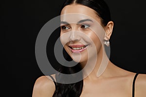 Young woman with elegant pearl earrings on black background, closeup. Space for text