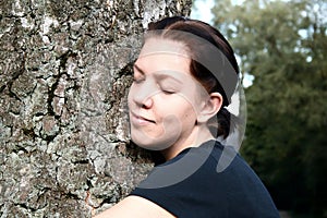 Young woman embrace big tree