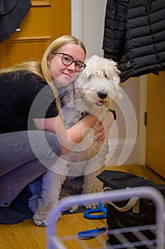 A young woman embraces an Old English Sheepdog