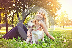 Young woman embracing her beagle puppy dog in the park