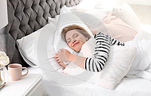 Young woman embracing pillow while sleeping in bed