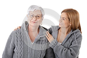 Young woman embracing senior mother smiling