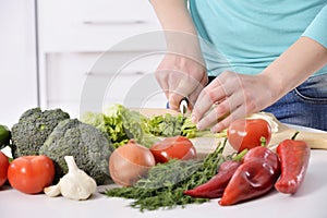 Woman cooking in new kitchen making healthy food with vegetables. photo