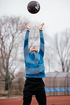 A young woman is engaged in sports on the Playground. Exercises with the medicine balls on the outdoor