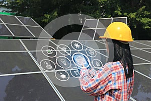 Young woman engineer checking solar panel with hologram at solar power plant